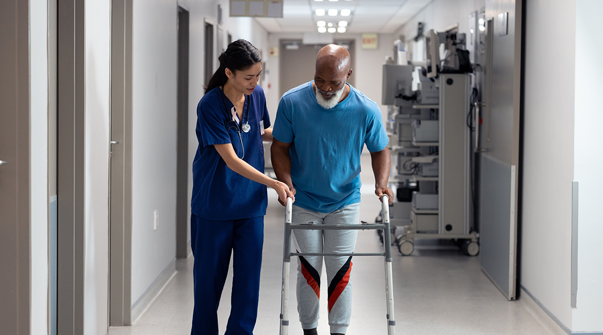 Patient recovering from surgery walking with help from nurse