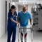 Patient recovering from surgery walking with help from nurse