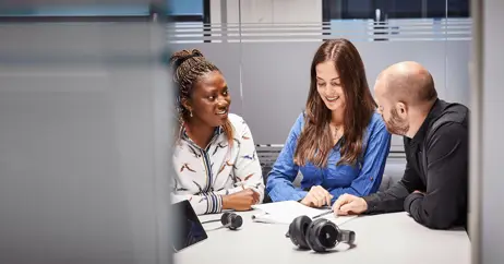 employees in a meeting discussing wireless headsets